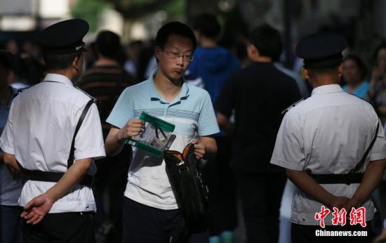 图为6月6日，南京大批高考考生走进当地一处考点看考场。中新社发 泱波 摄